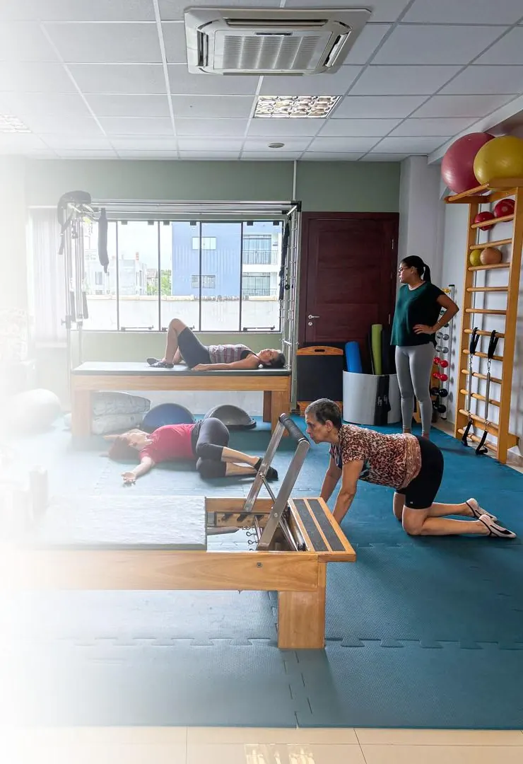 Fisioterapeuta acompanhando pacientes nos aparelhos da Clínica Mathitha